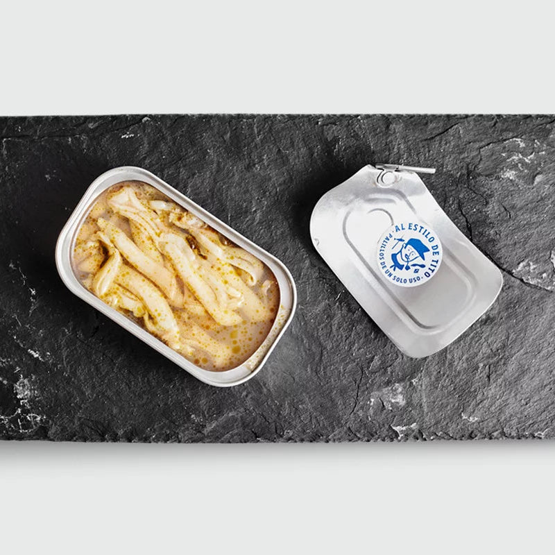 Plato de pizarra y sobre este una lata abierta de navajas al natural de de Conservas Tito.