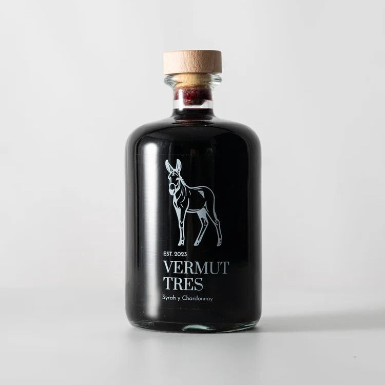 Botella en el centro de la pantalla de Vermut Tres Rocinante, con una silueta en blanco de un burro y bajo de ella el nombre del vermut.