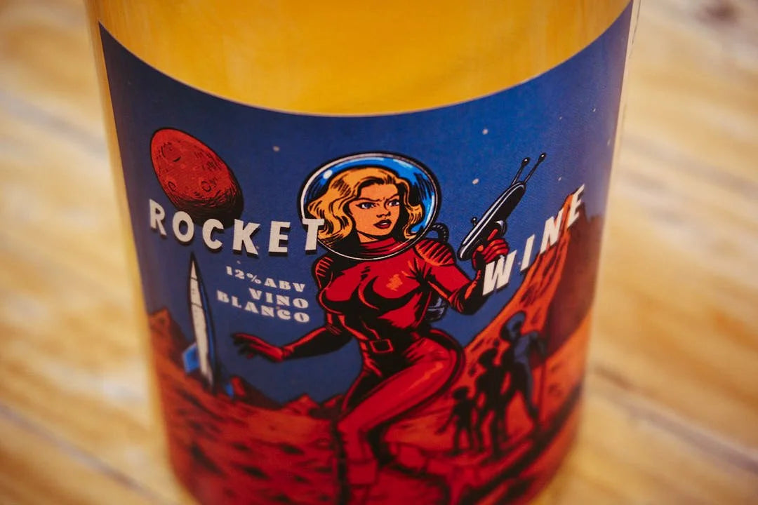 Detalle en plano corto de la etiqueta de la botella de vino Rocket Wine de Bodegas Yakka, mostrando en detalle la ilustración retro-futurista estilo ciencia ficción ochentera ambientada en Marte en D'12 Gourmet