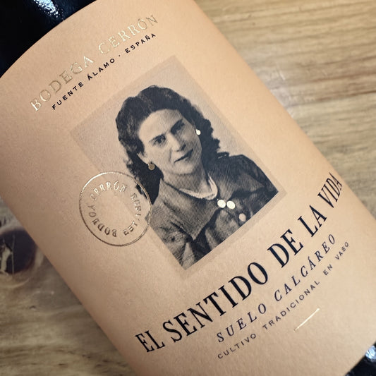 Primer plano de la etiqueta del vino El Sentido de la Vida de Bodega Cerrón, con fondo en tono salmón envejecido y una fotografía antigua de una mujer en el centro. Sobre y bajo la imagen se aprecia el nombre del vino y la información del producto.