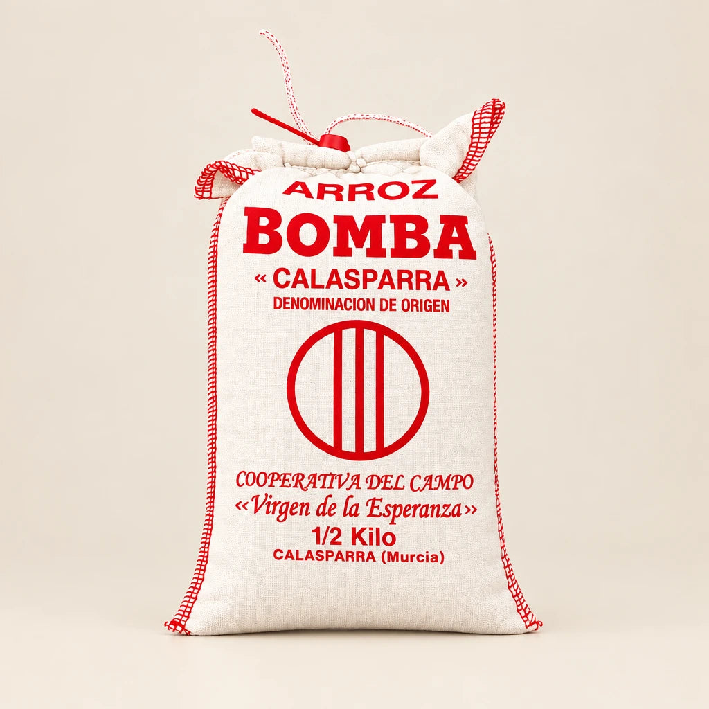 Saco de tela blanco con arroz bomba D.O. Calasparra sobre fondo de estudio, destacando la tipografía, información del producto y logotipo impresos en rojo en D'12 Gourmet
