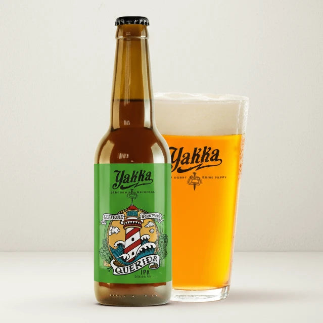 Botella de cerveza IPA con etiqueta verde y un faro dibujado servida en un vaso.