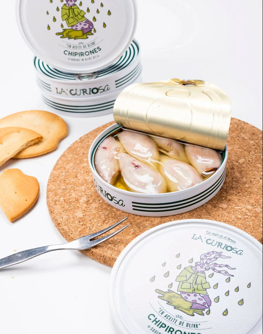 mesa con varios productos con lata de consrvas de chipirones en aceite de oliva virgen extra producto gourmet en d12 gourmet