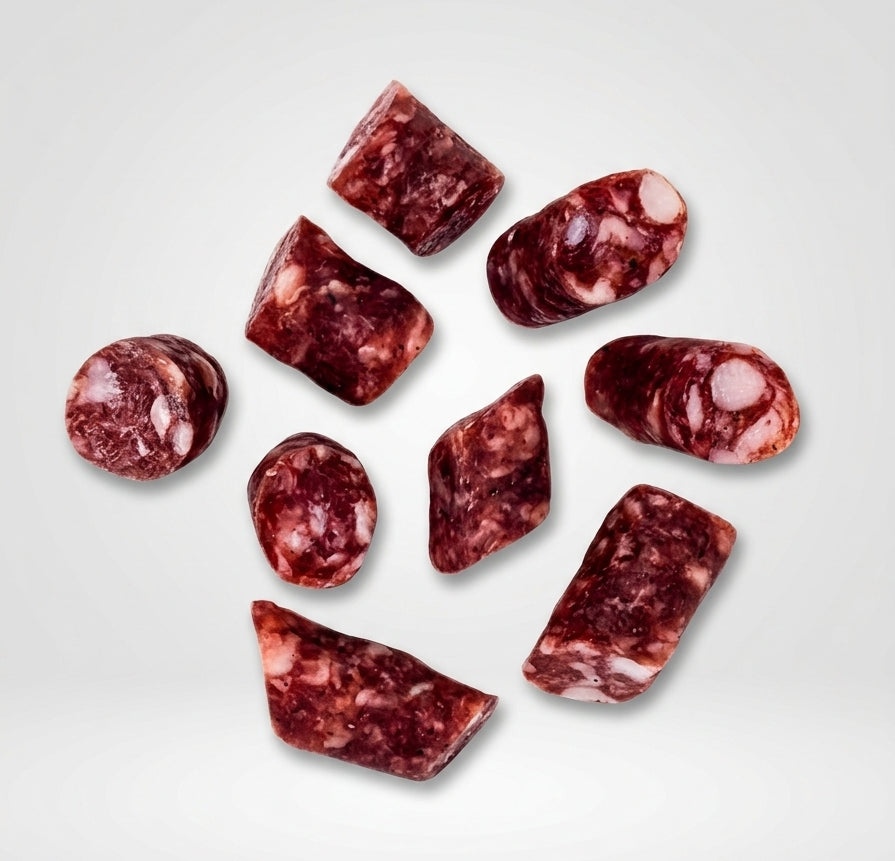 Salchicha de pellizco de chato murciano troceada sobre fondo blanco, embutido tradicional de la Región de Murcia presentado en varios cortes que muestran el interior del producto.