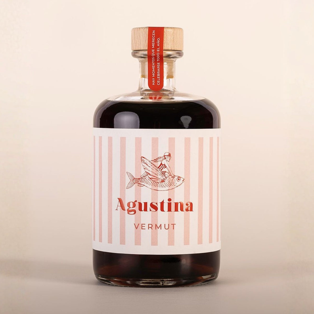 Botella de Vermut rojo Agustina sobre fondo blanco de estudio, con diseño moderno reutilizable y etiqueta de franjas rosas y blancas con el nombre en rojo e ilustración de una mujer cabalgando un ave alada en D'12 Gourmet