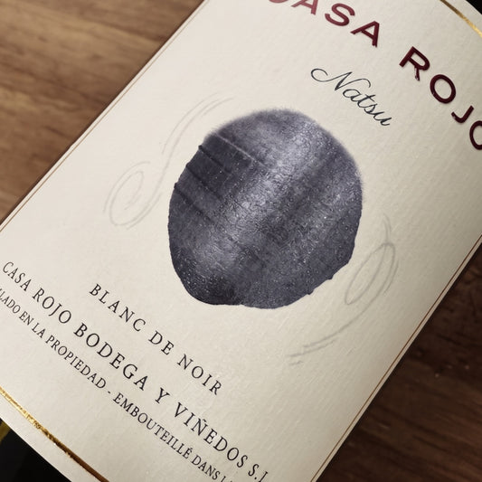 Primer plano de la etiqueta del vino Natsu de Bodegas Casa Rojo, con fondo en tono marrón envejecido y una ilustración central. Sobre y bajo la imagen se aprecia el nombre del vino, la bodega y la información del producto.