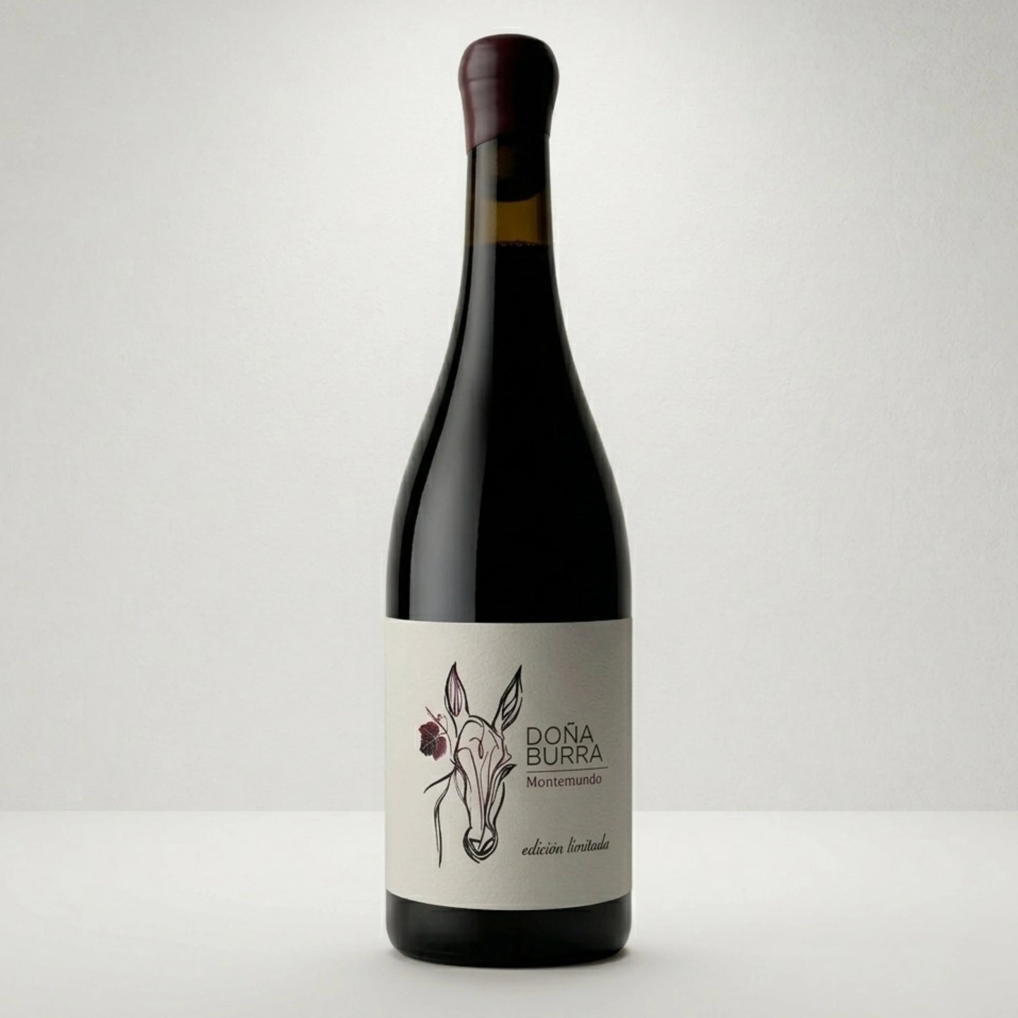 Botella de vino tinto Doña Burra. De estilo clásico donde observamos el dibujo de una burra con una flor y el nombre del vino.