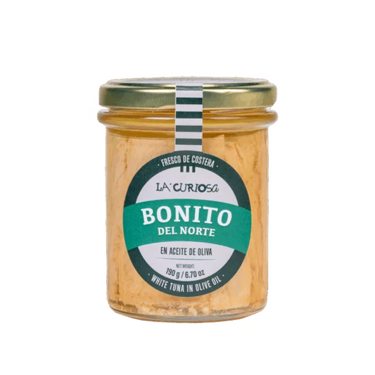 Bote de cristal con bonito del norte en aceite de oliva de la marca La Curiosa. Etiqueta en verde y blanco.