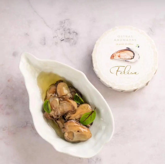 Deliciosas ostras ahumadas servidas en su mejor presentación, acompañadas de aceite de oliva para una experiencia gourmet inigualable.