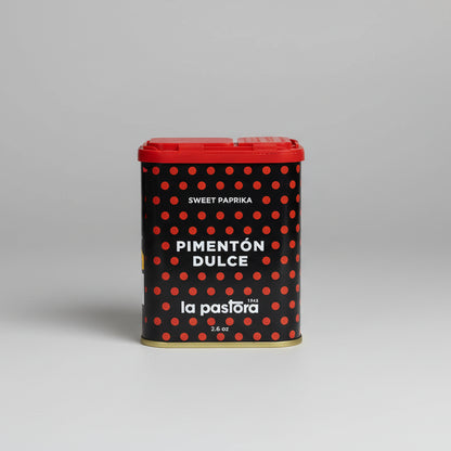 Lata de pimentón dulce La Pastora, pimentón de murcia. Bote negro con puntos rojos, letras en blanco y tapa roja con dos aperturas de diferentes calibres.