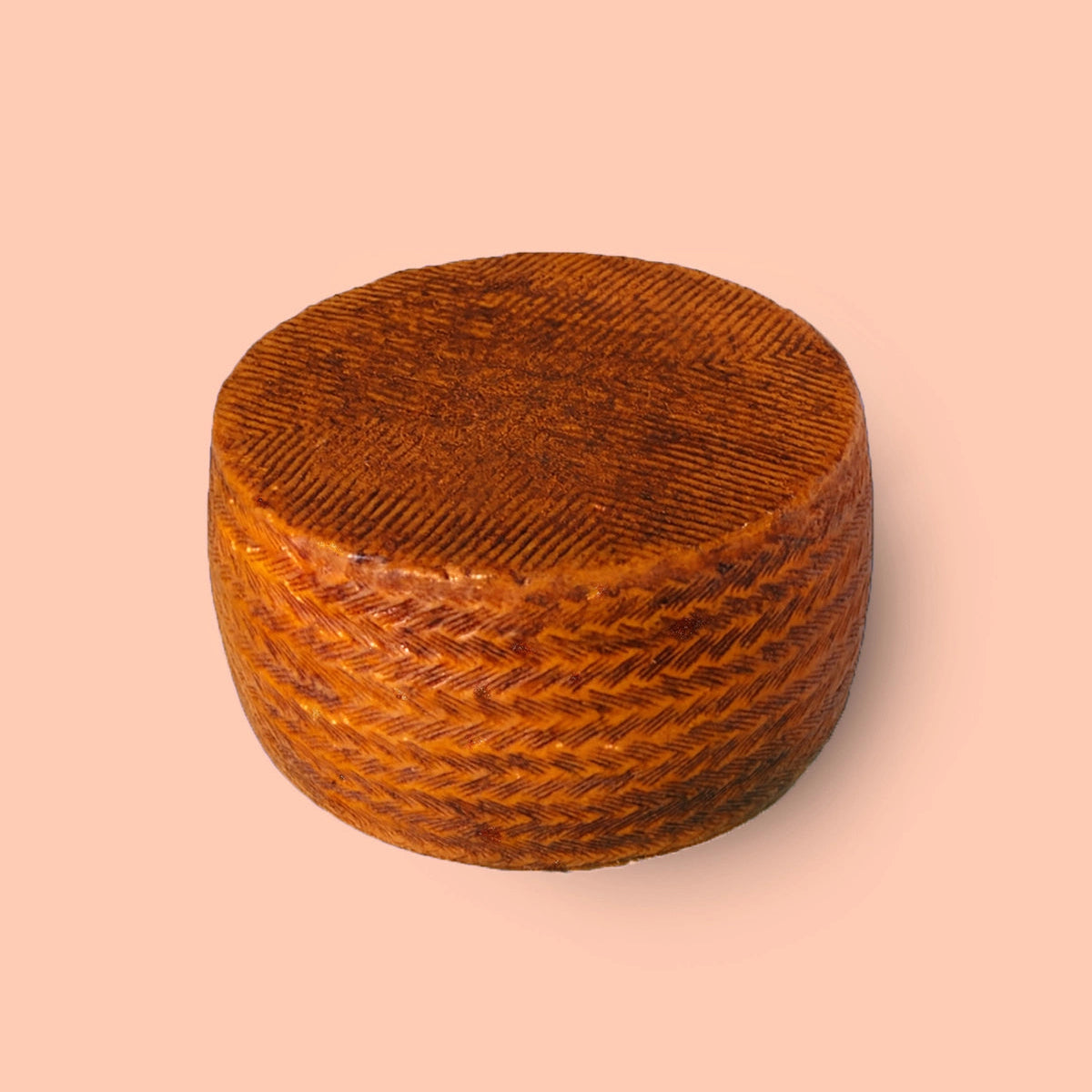 Sobre fondo rosa vemos un queso con corteza de pimentón.