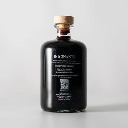 Una botella en el centro de la imagen, la parte de atrás del vermut Tres Rocinante donde se puede ver en blanco las recomendaciones y datos del vermut.