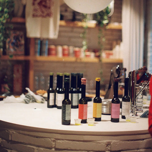 Mesa con las 4 variedades de aceite que tiene la marca Anécdota, parece ser una cata en una tienda.