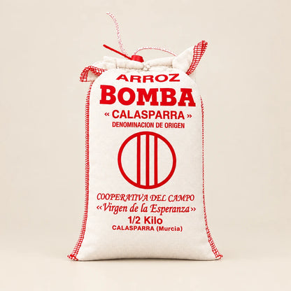 Saco de tela blanco con arroz bomba D.O. Calasparra sobre fondo de estudio, destacando la tipografía, información del producto y logotipo impresos en rojo en D'12 Gourmet
