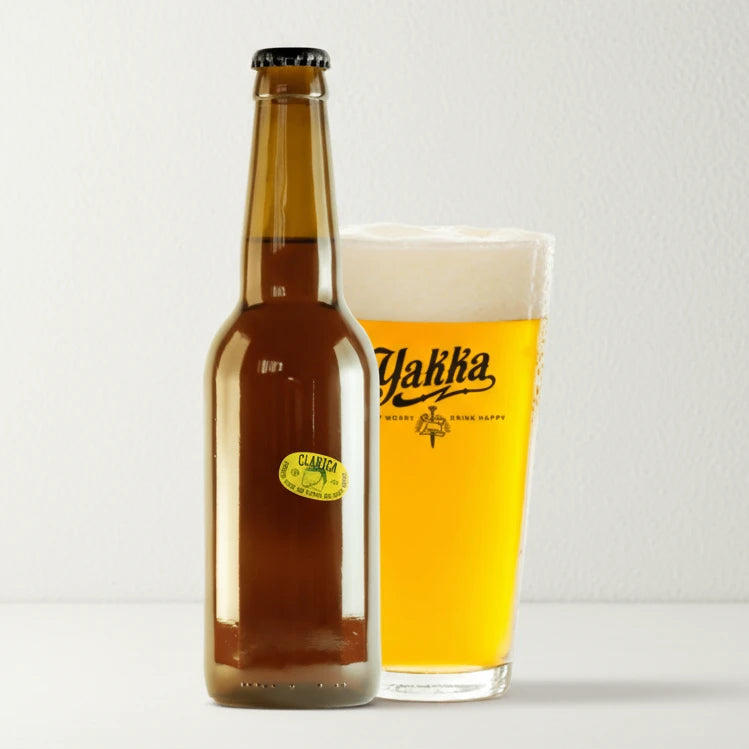 Botella de cerveza artesana Clarica acompañada de su vaso sobre fondo blanco