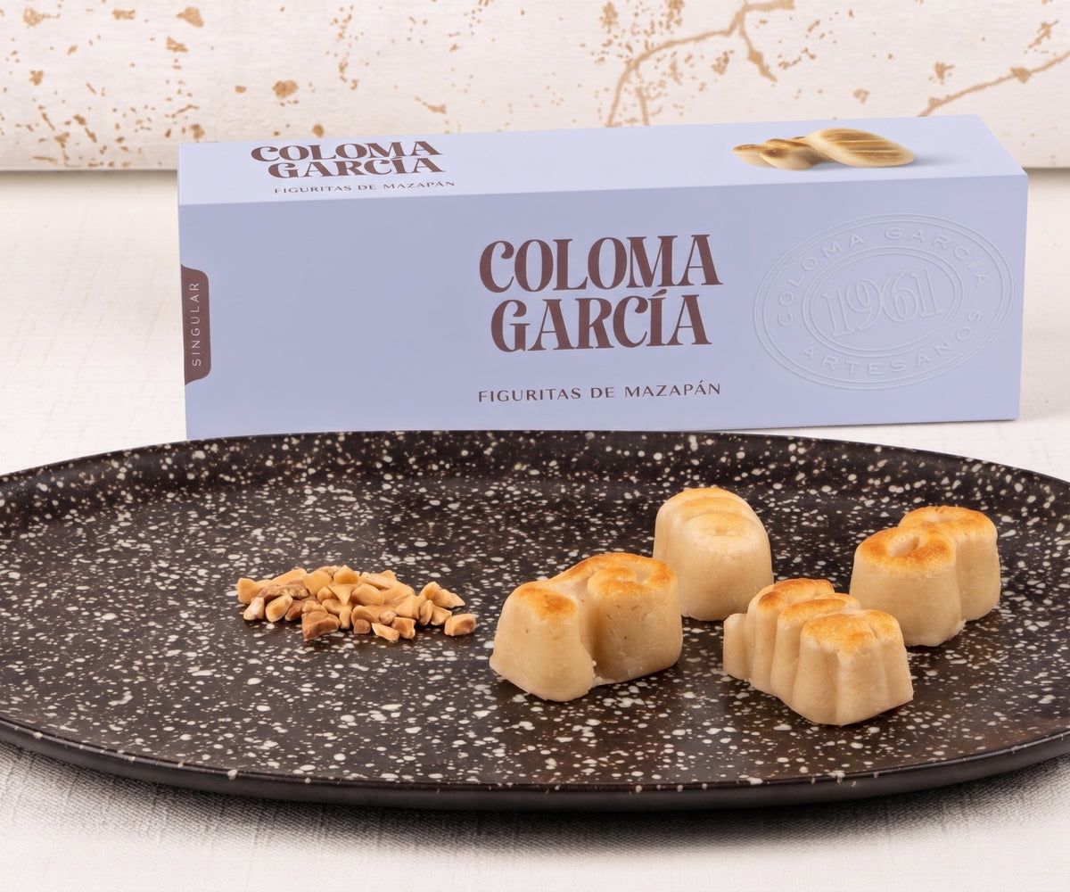 Plato con figuritas de mazapán de calidad suprema de Coloma García junto al estuche morado de la marca.