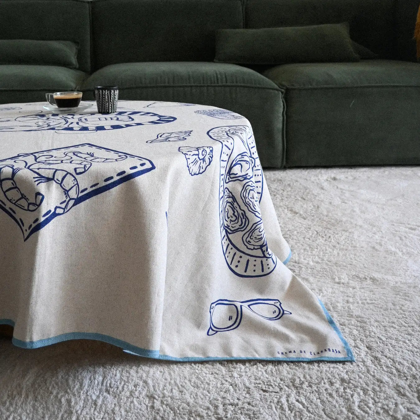 Mantel liso con elementos de comida marina y otros en color azul, hecho en España ideal para decorar tu mesa con gran originalidad en D'12 Gourmet.