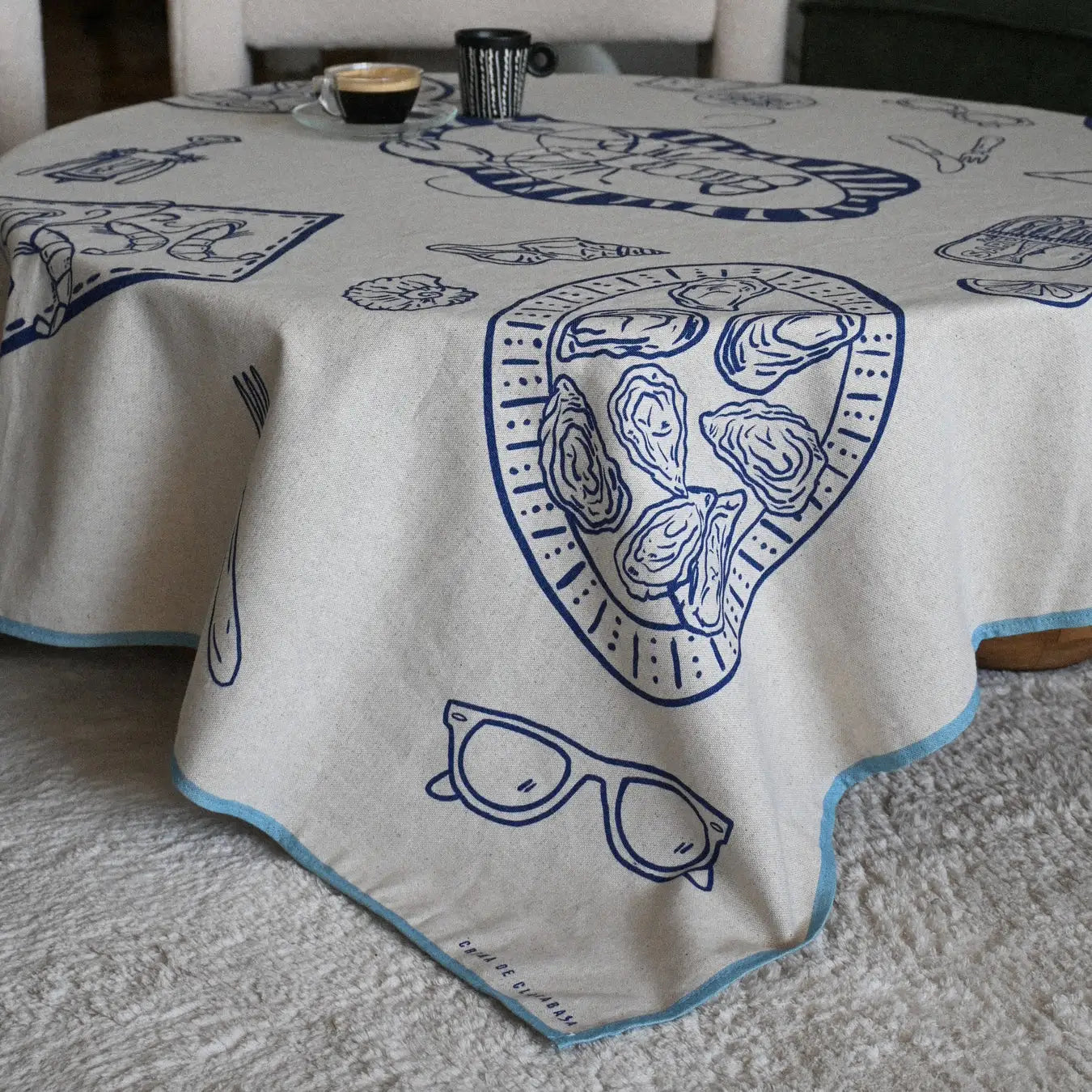Mantel sencillo hecho en España de algodón con elementos marinos y comida en color azul. De gran calidad y muy moderno en D'12 Gourmet