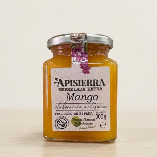 Bote con mermelada de mango realizada de forma artesanal, con etiqueta de diseño tradicional con el nombre de la empresa, Apieriserra, y la fruta de la mermelada.