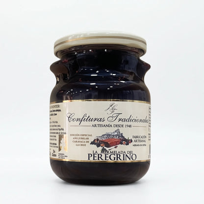 Frasco transparente de confitura La Mermelada del Peregrino con etiqueta blanca, dejando ver la mermelada de higos y moras y mostrando la ilustración de las frutas junto a la marca.