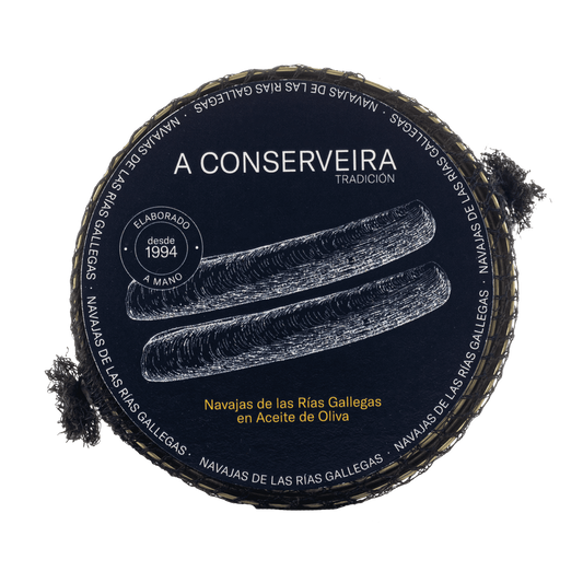 Lata de conserva de Navajas de las Rías Gallegas en Aceite de Oliva. Envase circular con rejilla de pesca y pegatina azul con letra y dibujo de las navajas en blanco.