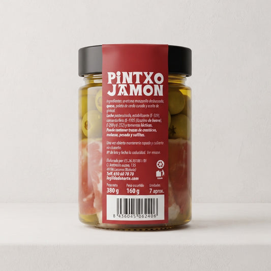 Bote de pintxos de queso, jamón y aceituna sobre fondo blanco, con etiqueta de color granate y tipografía blanca donde se muestra el nombre y la información del producto.