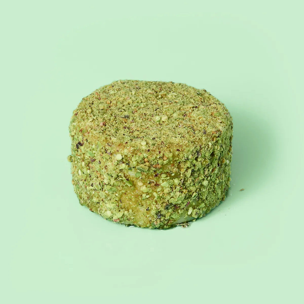 Sobre fondo verde queso de tamaño mini de miel y pistacho.