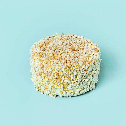 Sobre fondo azul claro queso mini de quesos Cerrón de cabra afinado con almendra miel ecológico.