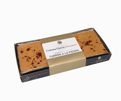 Tableta de turrón a la piedra artesanal Coloma García en envoltorio transparente sobre fondo de estudio.