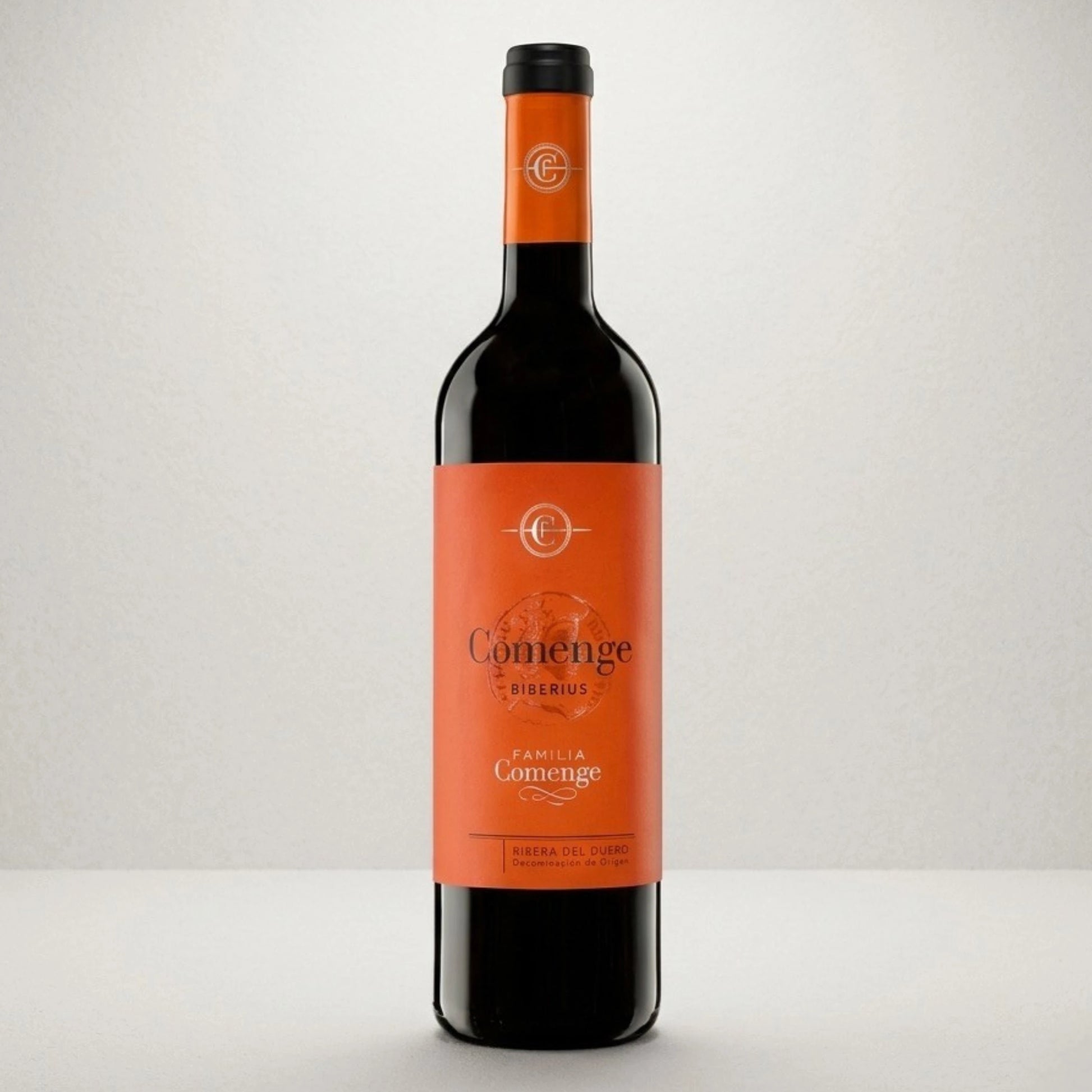 Botella de vino tinto Comenge Biberius con denominación de origen Ribera del duero 100% Tempranillo. De color naranja la etiqueta y el tapón con letras negras y doradas.