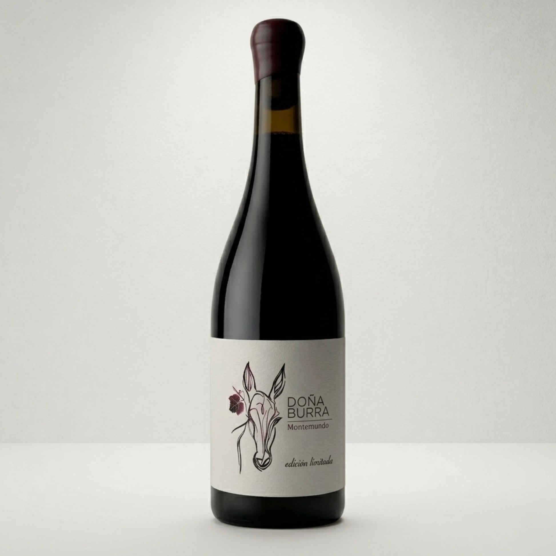 Botella de vino tinto Doña Burra. De estilo clásico donde observamos el dibujo de una burra con una flor y el nombre del vino.