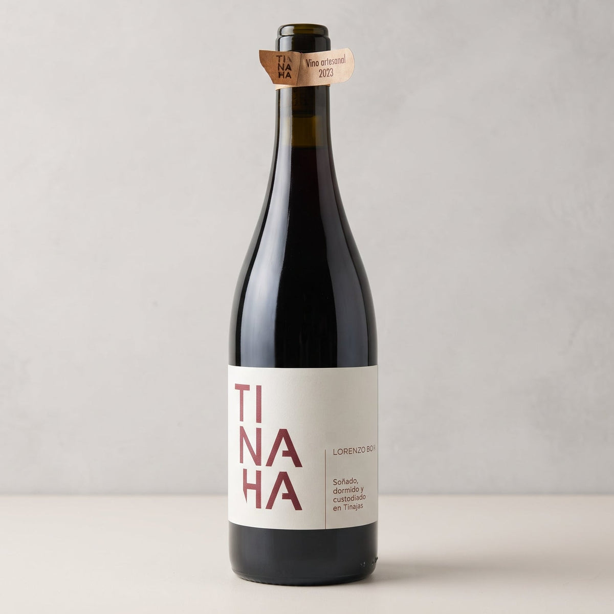 Botella de vino Tinaja sobre fondo de estudio. Diseño clásico con etiqueta blanca y el nombre «TINAJA» en letras rojas divididas en tres líneas.