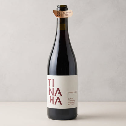 Botella de vino Tinaja sobre fondo de estudio. Diseño clásico con etiqueta blanca y el nombre «TINAJA» en letras rojas divididas en tres líneas.